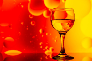 transparent glass with water and oily drops on background 