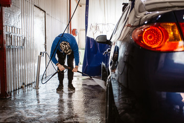Car wash services, a man washes the car with a kercher
