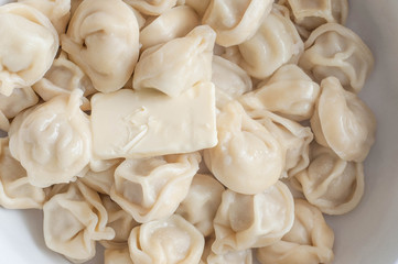 A plate of freshly cooked hot dumplings with a slice of butter melting in them from the temperature to give an appetizing taste