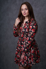 Portrait of a female in a colored dress on gray background