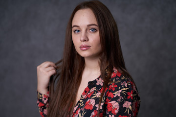 Portrait of a female in a colored dress on gray background