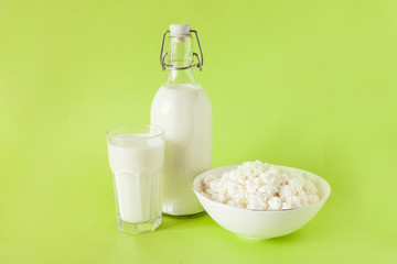 milk in a bottle cottage cheese and a glass of milk on a green background