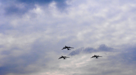 Silhouettes flying Russian Tu-95 bombers against the sky.