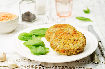 red lentil seeds cashew carrot burgers with fresh spinach leaves