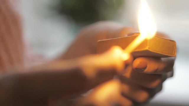 Girl's hand striking a match