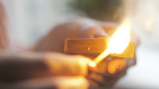 Girl's hand striking a match