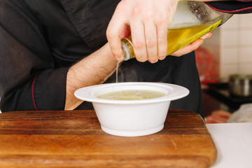 Water the oil on cauliflower cream soup. Hands. Cook. Chef