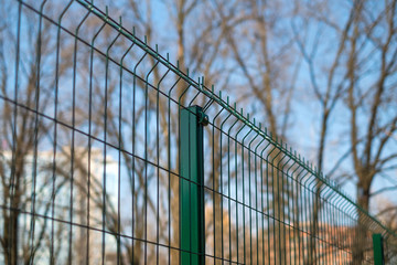 Steel grating fence made with wire on blue sky background. Sectional fencing installation