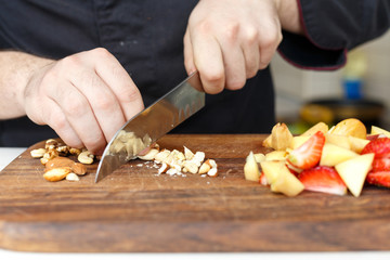 Cook cuts berries and nuts. Blueberry. Wooden. Homemade. Hands. Making. 