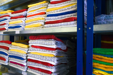 towels, bed sheets and clothes on the shelf