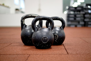 Fototapeta na wymiar Тhree black iron kettlebells with markings 24 and 16 kg. Workout tools