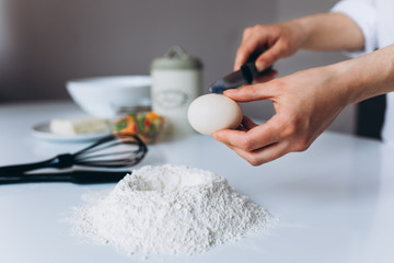 Female Hands Beat the Egg Yolk Into the Flour