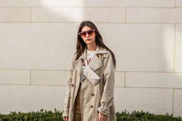 Portrait shooting of a stylish girl. Beige shades. Trends of spring and summer 2019. Pants of cork.Trench cloak, a wide jacket.