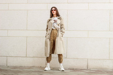 Portrait shooting of a stylish girl. Beige shades. Trends of spring and summer 2019. Pants of cork.Trench cloak, a wide jacket.