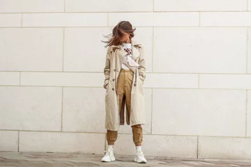 Tapeten Portrait shooting of a stylish girl. Beige shades. Trends of spring and summer 2019. Pants of cork.Trench cloak, a wide jacket. © Yaroslav