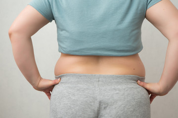 fat girl on diet, Overweight fat woman with a little portion of food trying to lose weight. Extreme diet,woman's hand holding excessive belly fat, the concept of weight loss