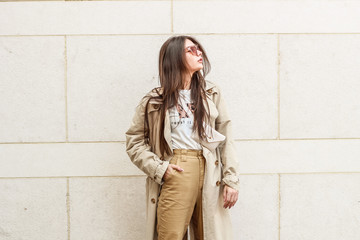 Portrait shooting of a stylish girl. Beige shades. Trends of spring and summer 2019. Pants of cork.Trench cloak, a wide jacket.