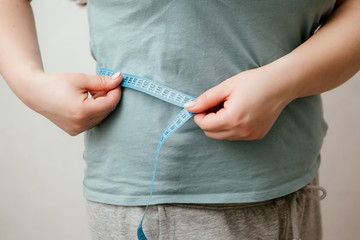 fat girl on diet, Overweight fat woman with a little portion of food trying to lose weight. Extreme diet,woman's hand holding excessive belly fat, the concept of weight loss