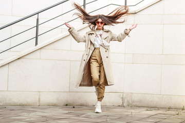 Portrait shooting of a stylish girl. Beige shades. Trends of spring and summer 2019. Pants of cork.Trench cloak, a wide jacket.