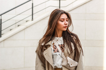 Portrait shooting of a stylish girl. Beige shades. Trends of spring and summer 2019. Pants of cork.Trench cloak, a wide jacket.