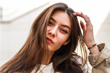 Fototapeta premium Portrait shooting of a stylish girl. Beige shades. Trends of spring and summer 2019. Pants of cork.Trench cloak, a wide jacket.