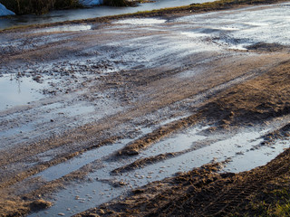 dirty rural road with deep tire tracks