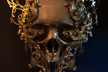 golden skull made with 3d printer and pieces by hand. Gothic piece of decoration for halloween or horror scenes