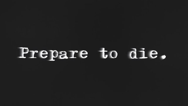 A scary text, Prepare to die, appearing on the screen with a light behind the typewriter font, typical of a horror flick (b-movie).
