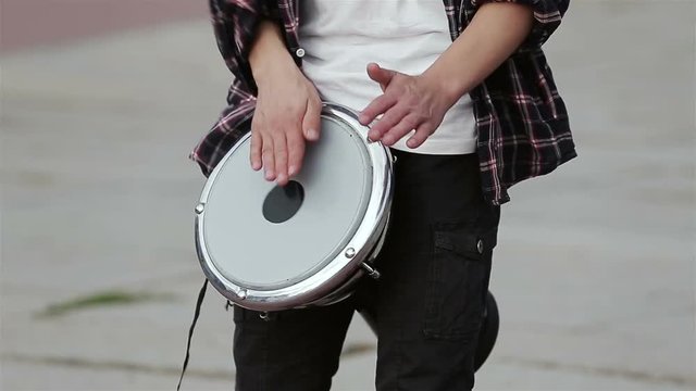 Musician playing on a bongo drum. Drummer hands. Street drummer close up