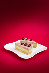 Sliced of Red bean cheese cake on white plate on red Background.