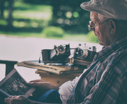 Senior Man Looking At Old Photos