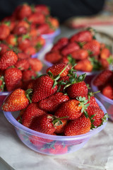 Fresh strawberry in a plastic bowl, close-up, top view, healthy detox food