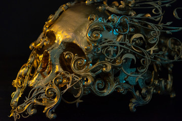 Gold, golden skull made with 3d printer and pieces by hand. Gothic piece of decoration for halloween or horror scenes