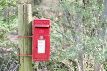 Red post box in Scottish rural location in countryside by Loch Tay