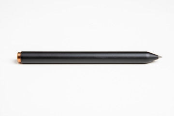 A macro shot of a minimalist sleek black barrel clicker ballpoint pen with selective focus on its writing tip.