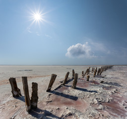 dry saline land at with old wooden construction under a sparkle sun