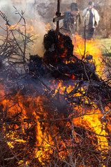 Flaming fire. Burning tree branches. Pagan rite dedicated to the arrival of spring. Big bonfire on Shrovetide. 