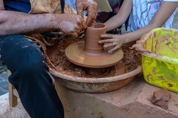 Potter teaches children at craft fair