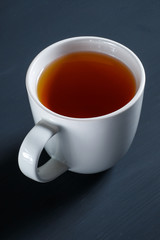 Top view cup of tea on black wooden table.