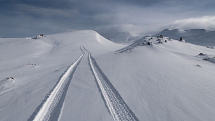 Superjeep driving on snow creating tracks in Iceland winter in landmannalaugar