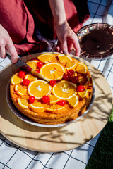 Female cut pie with oranges for a event day on picnic checked  cloth
