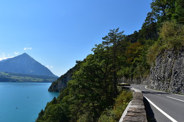 Road by the Lake Thun of Switzerland and mountains in background in a very nice and sunny summer day