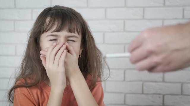 Cigarettes and child. The little girl is choking on the cigarette smoke.