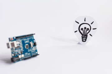 Arduino Uno. Arduino. Micro controller. Technology. Picture of a light bulb in the background. Idea. The science. Industrial.