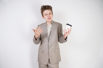 teenager male in gray business suit with paper Cup of coffee in hand on white studio background
