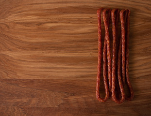 Hunting sausages smoked for beer on a wooden background. Raw smoked meat products. Homemade food cooked at home. Delicious delicacies.