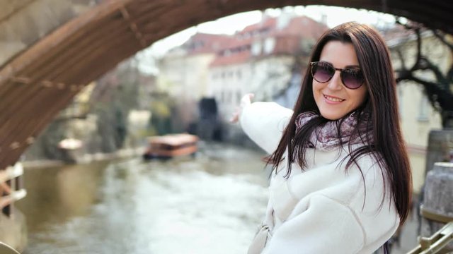 Attractive smiling female tourist admiring amazing river view from city embankment