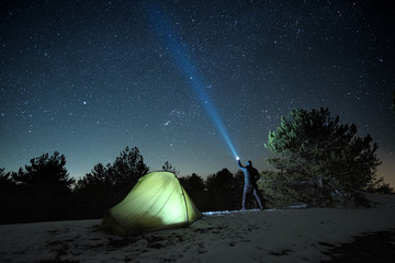 Man Pointing Blue Flashlight To Starry Sky