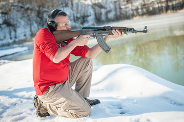 Civilian in crouching position shooting from rifle machine gun