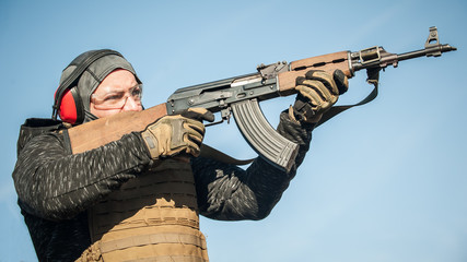 Military soldier in action combat shooting from rifle machine gun